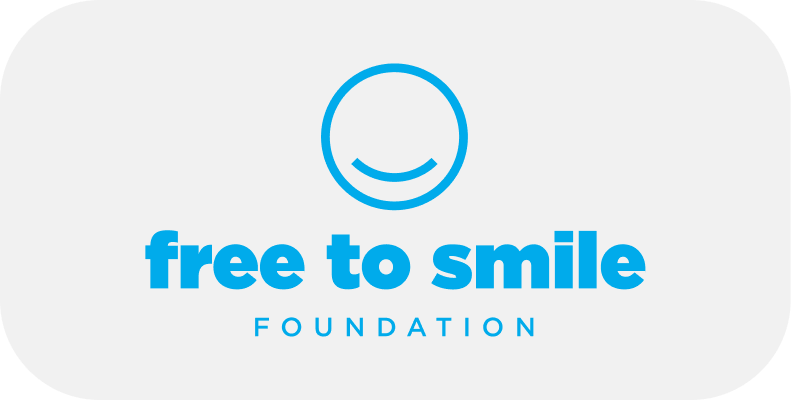 A blue logo features a smiling face above the text "free to smile FOUNDATION" on a white background with rounded corners.