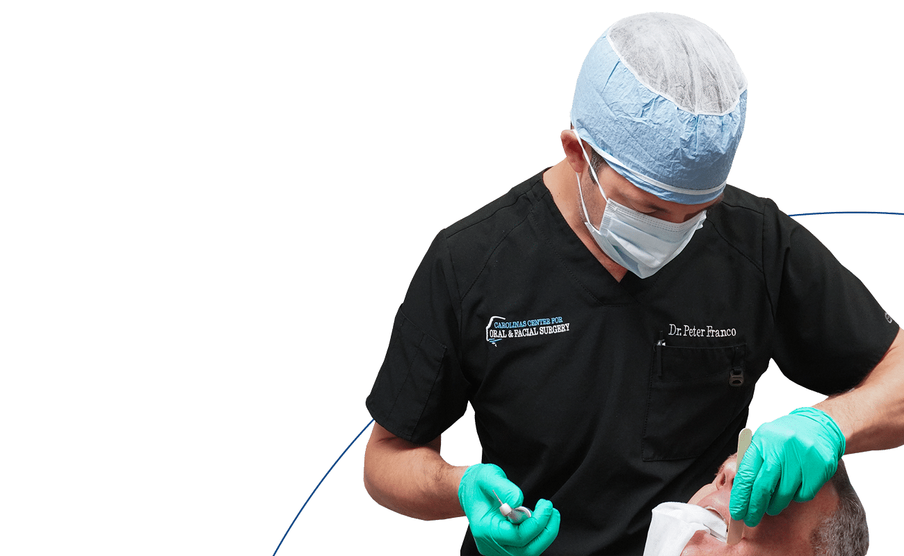 A medical professional, in surgical attire, examines a patient. The background is plain with blue accents. The focus is on oral and facial care.