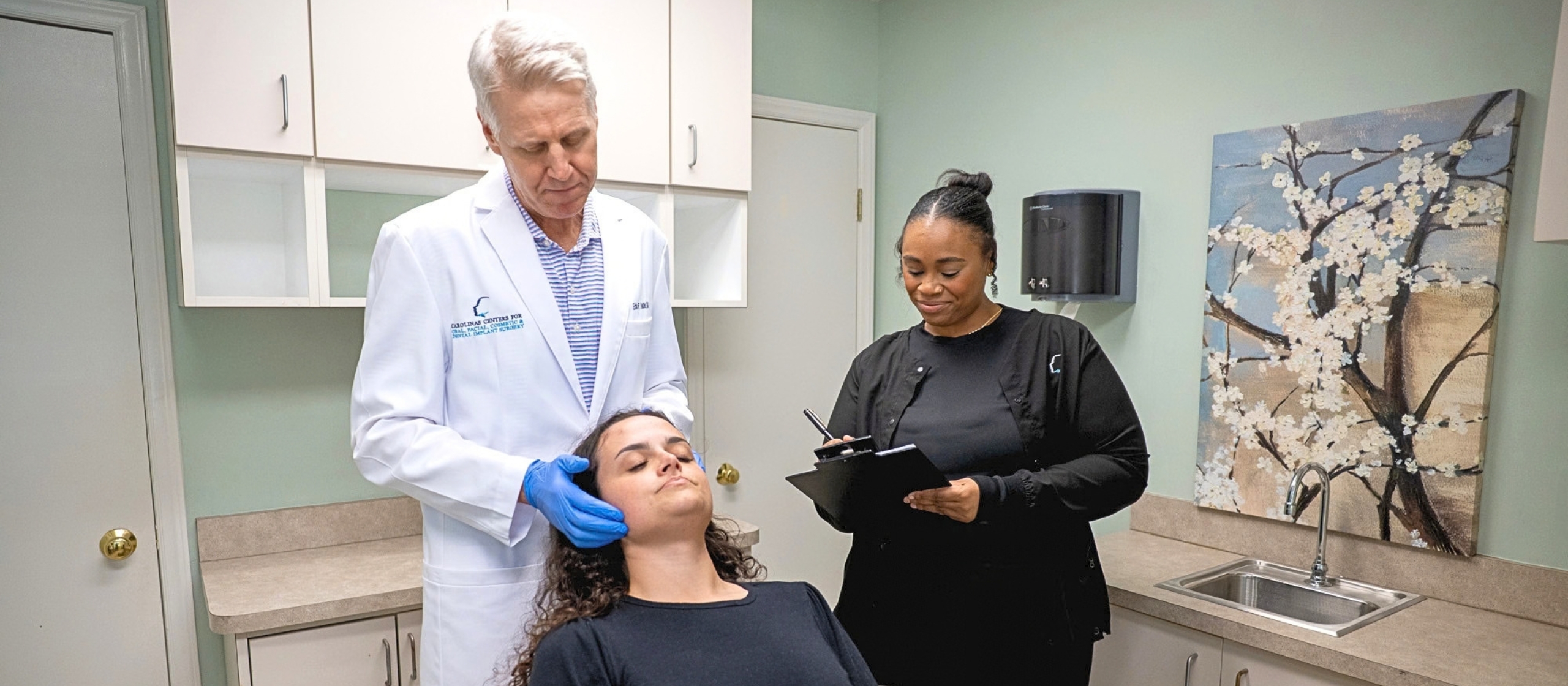 Dr. Reitter Oral and Maxillofacial Surgeon in Charlotte, NC assessing patient with assistant.