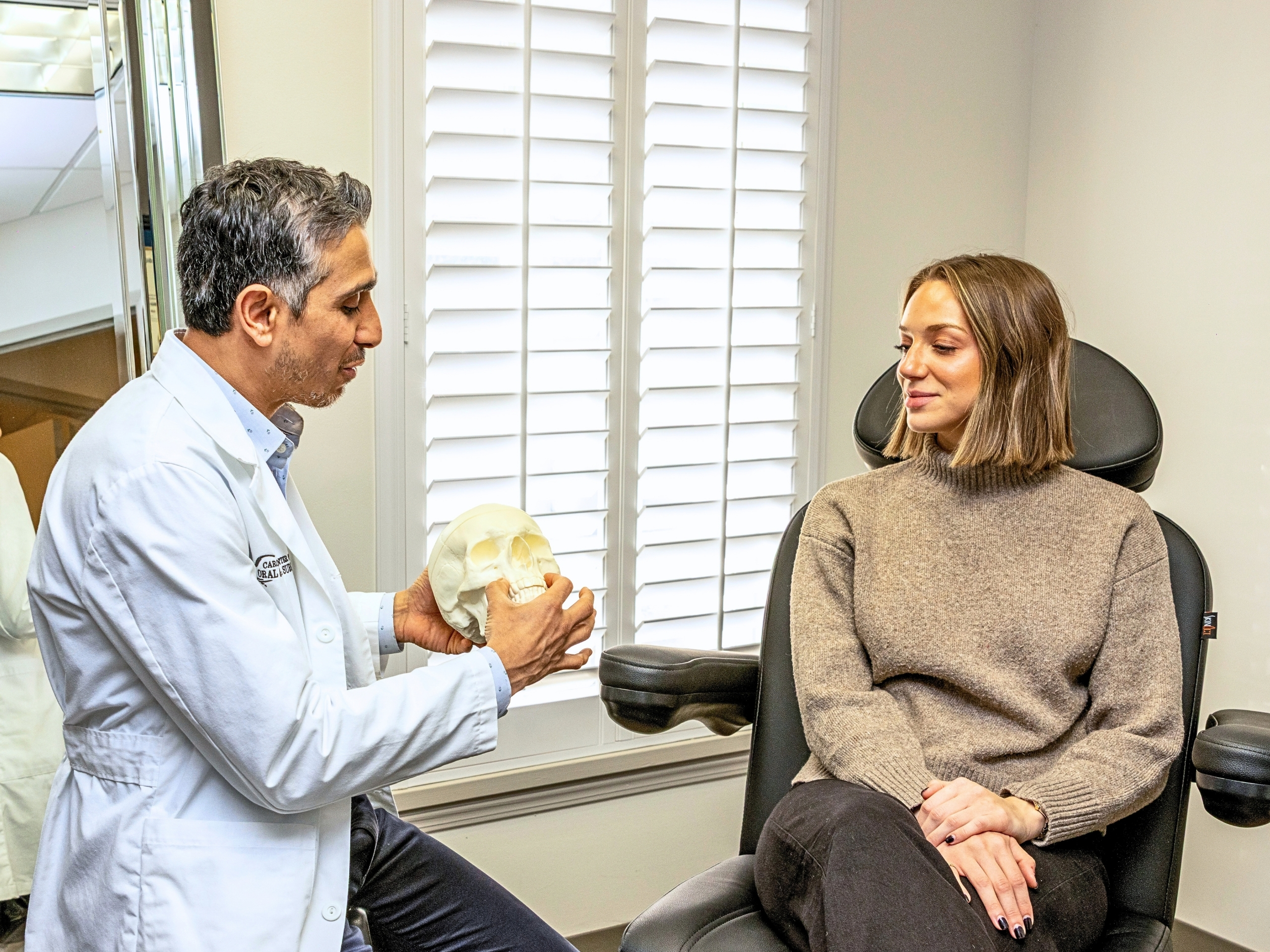 Dr. Waheed Mohamed Cosmetic Surgeon and Oral & Maxillofacial Surgeon in Charlotte, NC has a consultation with a patient
