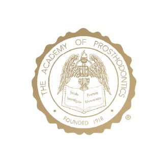 The gold emblem of "The Academy of Prosthodontics," established in 1918, features an eagle with an open book.