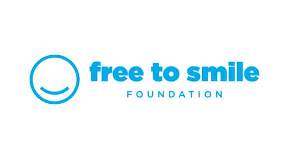 Blue "Free to Smile Foundation" logo with a stylized smile. Words are bold and clear, creating a positive, welcoming impression.