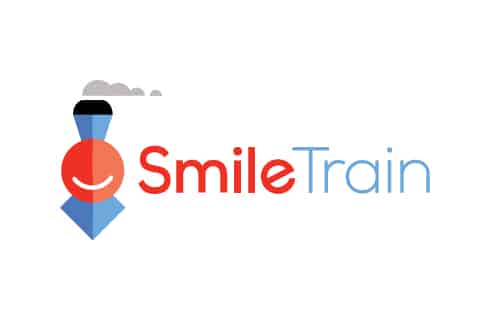Logo featuring a red smiling face forming a train shape with the text "Smile Train" in red and blue. Simple, cheerful design.