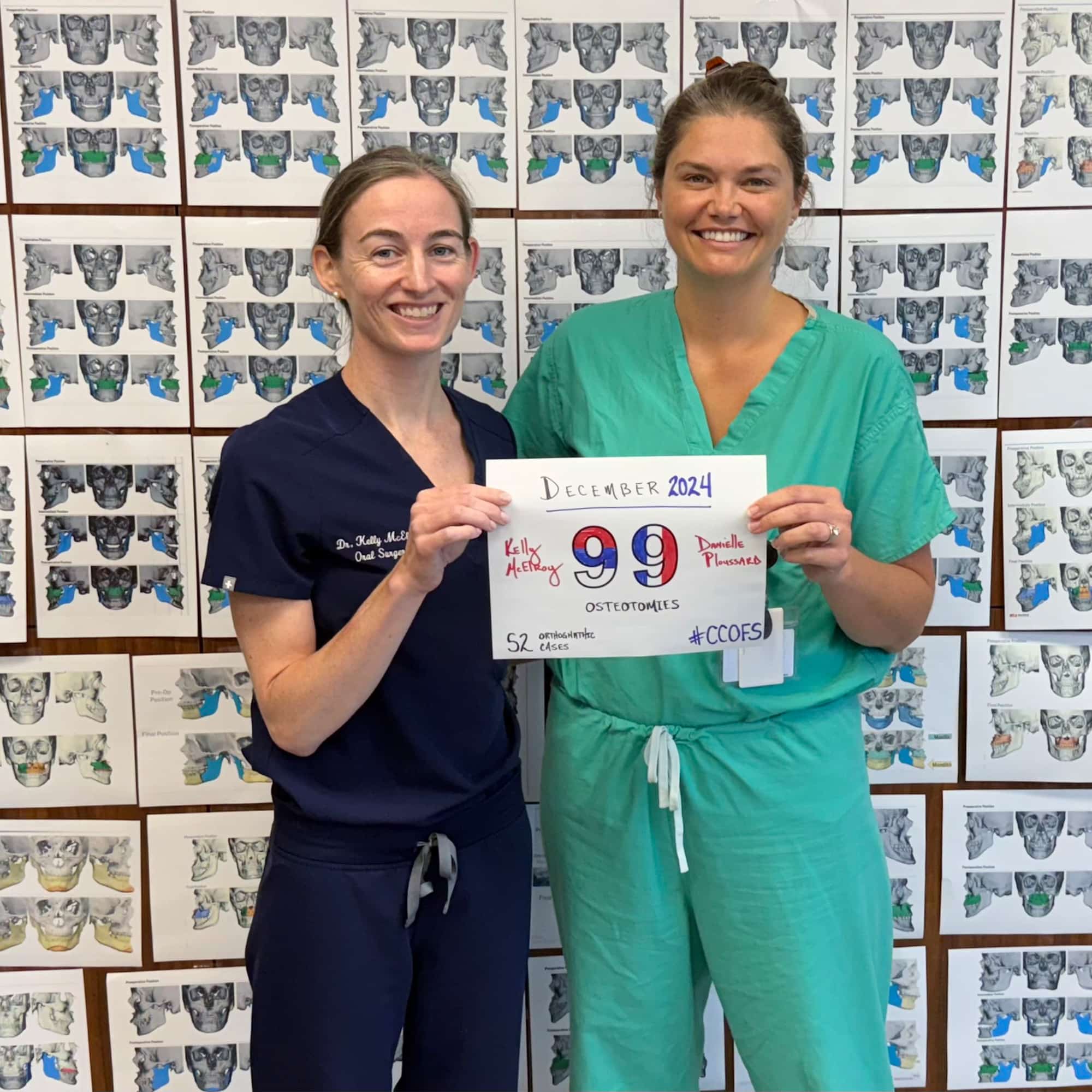 Two people in scrubs hold a sign about osteotomies. They stand in front of a medical diagram wall display.