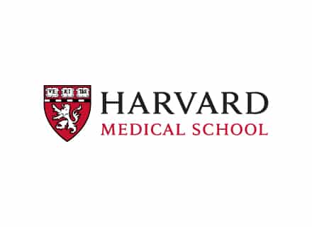 The image shows the Harvard Medical School logo, featuring a red shield with a lion and the words "VERITAS" and "Harvard Medical School."