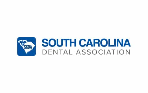 Logo of the South Carolina Dental Association with a symbol featuring the state outline and initials "SCDA" in blue and gray colors.