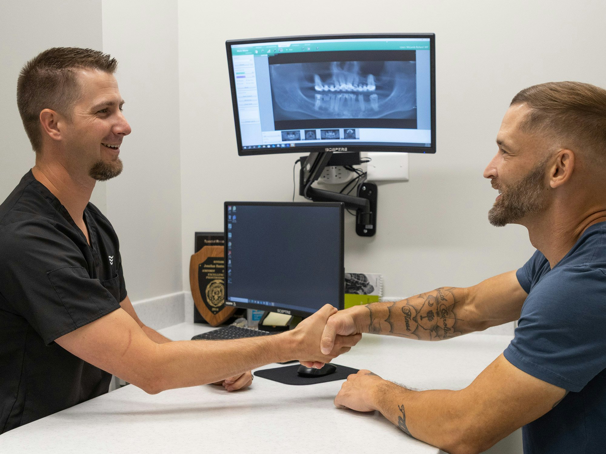 Richard and Dr. Hunter Dawson reviewing xrays of Richards full arch dental implant restoration