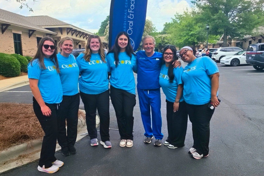 Dr JD Kisella and Carolina Center for Oral and Facial Surgery staff members gathered outside for a community event in Matthews, NC
